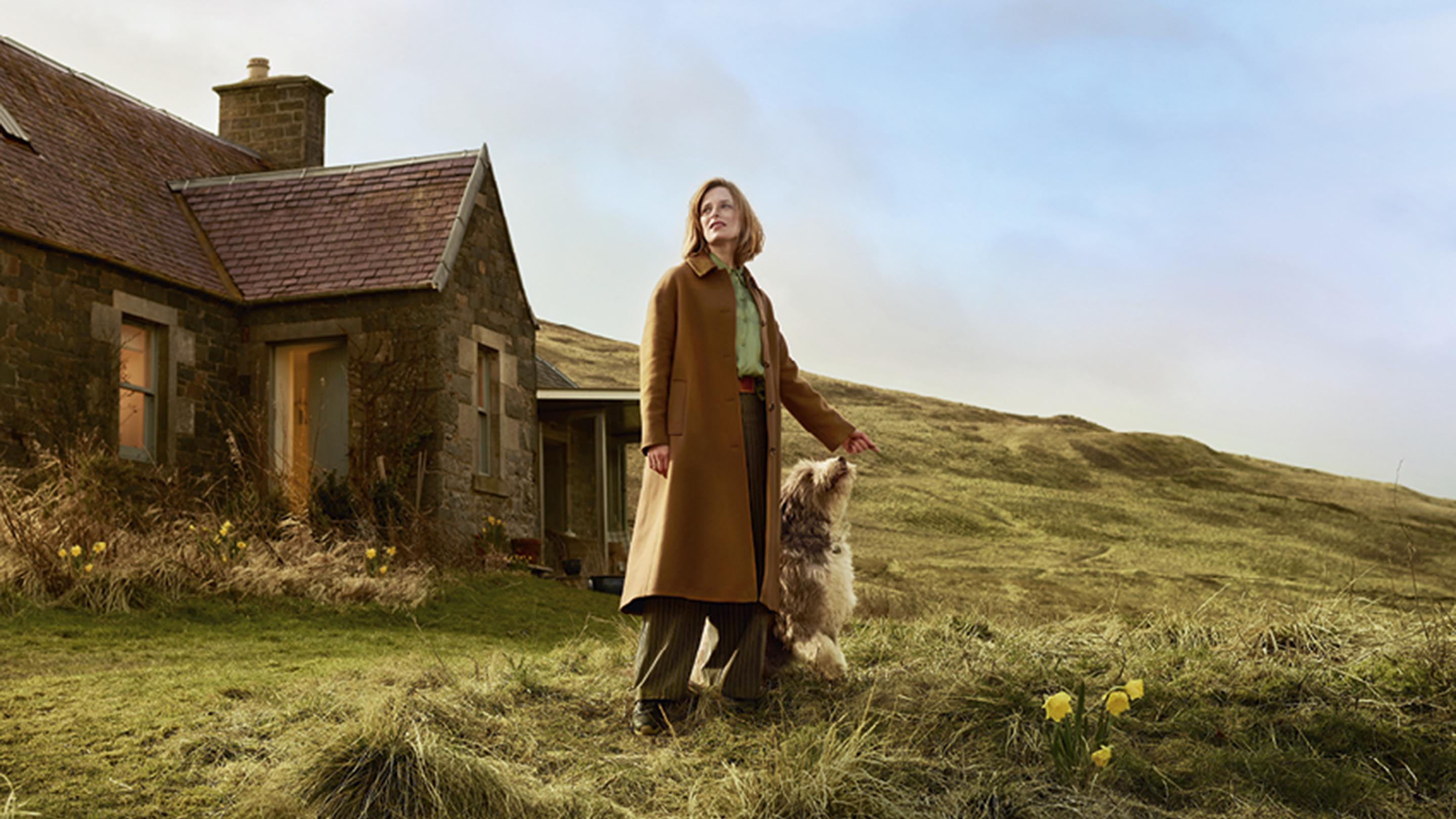 Image: woman in front of country house
